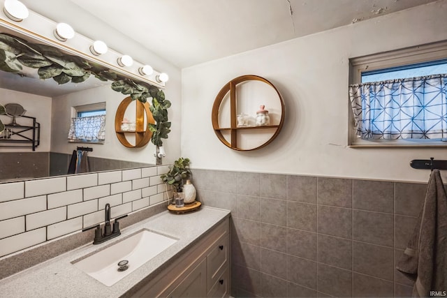 bathroom featuring wainscoting, tile walls, and vanity