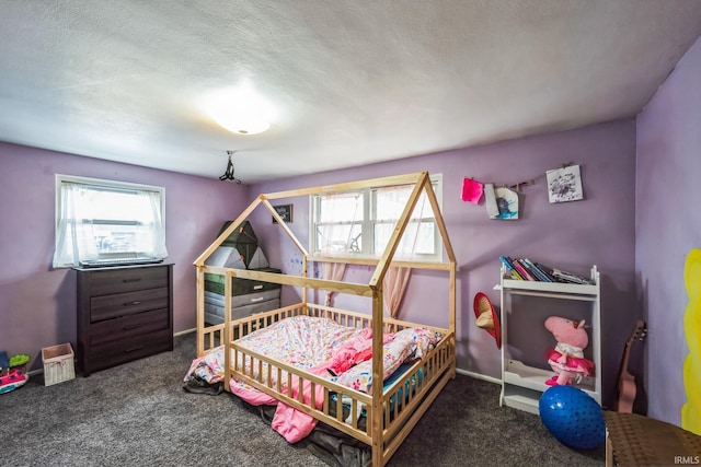 bedroom with a textured ceiling, carpet flooring, and baseboards