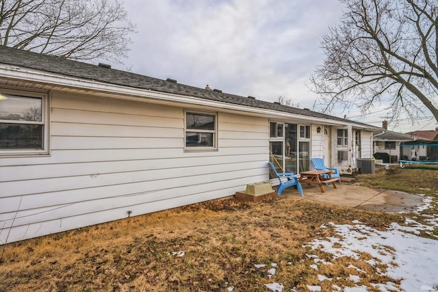 back of property with a trampoline, cooling unit, and a patio