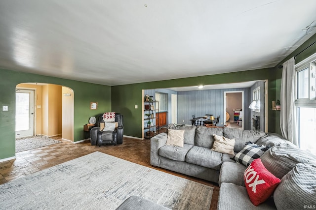 living room with baseboards and arched walkways