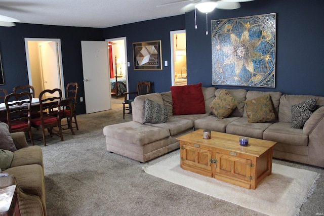 carpeted living area featuring a ceiling fan