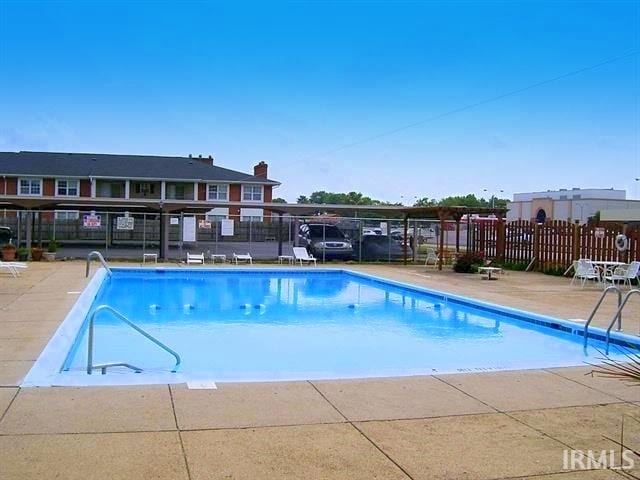 pool featuring fence and a patio