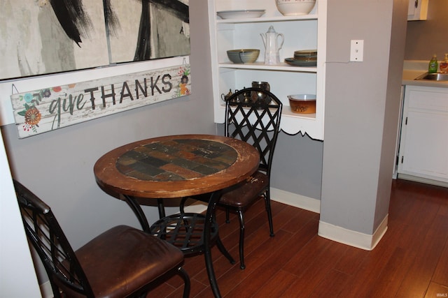 dining area with dark wood finished floors and baseboards