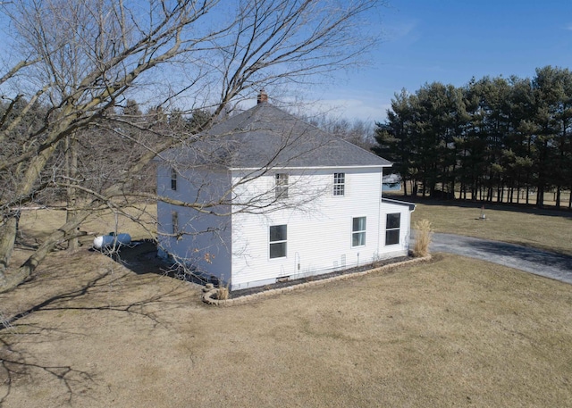 view of home's exterior with driveway and a lawn