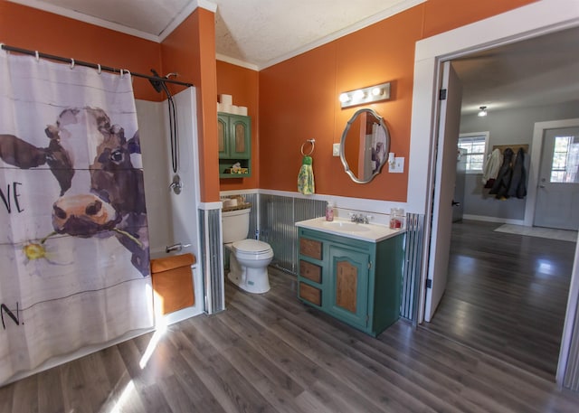 bathroom with crown molding, curtained shower, toilet, vanity, and wood finished floors