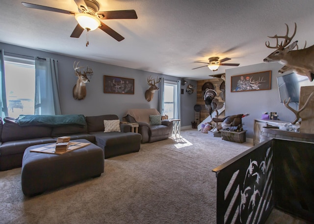 living area with a textured ceiling, a ceiling fan, and carpet flooring