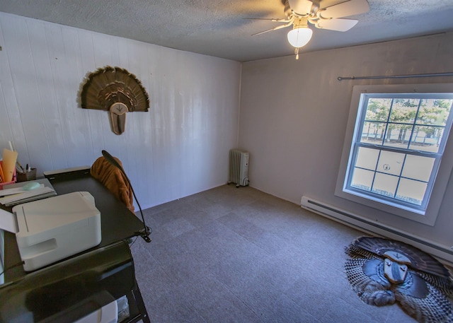 office area with a textured ceiling, a baseboard heating unit, ceiling fan, and radiator