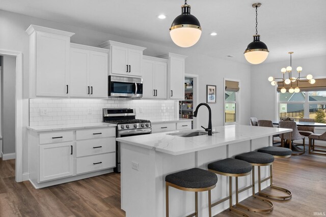 kitchen featuring dark wood-type flooring, appliances with stainless steel finishes, backsplash, and a sink