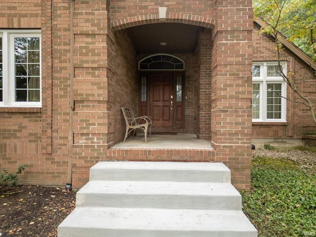 view of exterior entry with brick siding