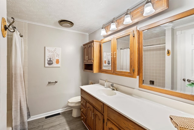 bathroom featuring toilet, wood finished floors, vanity, visible vents, and baseboards