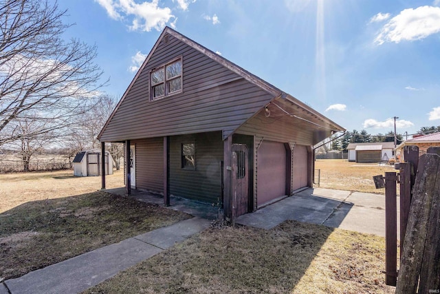 view of side of property featuring a storage shed, an outdoor structure, and a detached garage