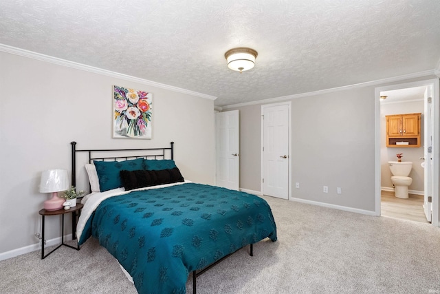 carpeted bedroom featuring ensuite bath, a textured ceiling, baseboards, and crown molding