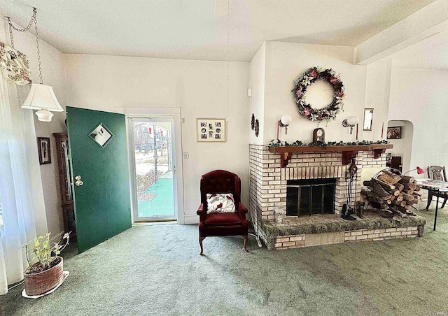 living area featuring carpet floors, arched walkways, and a fireplace