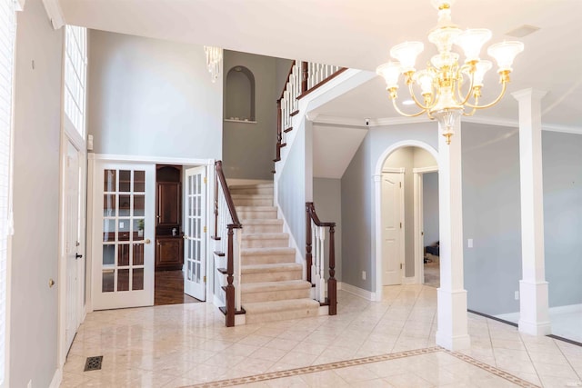 entrance foyer featuring french doors, crown molding, decorative columns, stairway, and baseboards