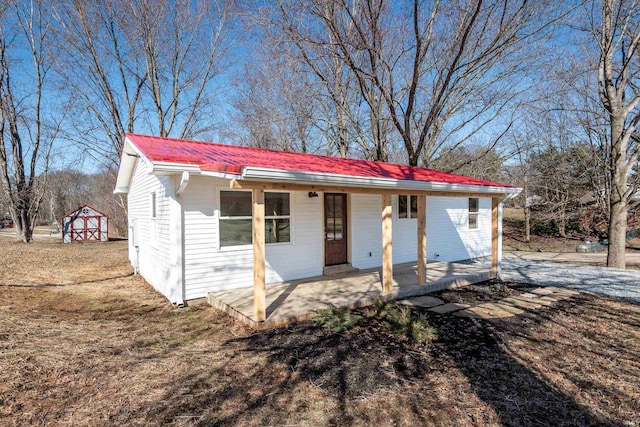 view of front of home with covered porch, metal roof, and an outdoor structure