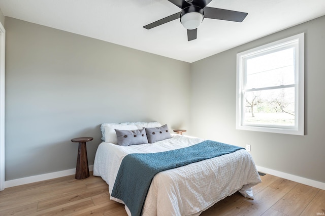 bedroom featuring ceiling fan, light wood finished floors, and baseboards