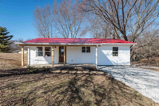 ranch-style home featuring metal roof and a porch