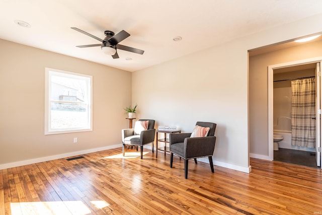 living area with light wood finished floors, visible vents, baseboards, and ceiling fan