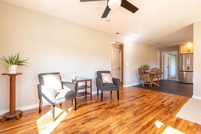 sitting room with light wood-style floors, ceiling fan, and baseboards