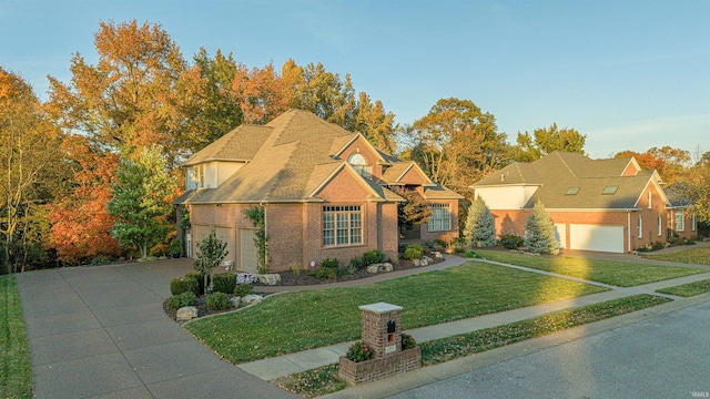 view of front facade featuring brick siding, roof with shingles, concrete driveway, a garage, and a front lawn