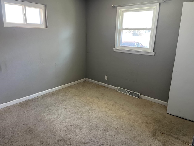 carpeted empty room with visible vents and baseboards