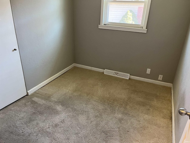 carpeted empty room featuring visible vents and baseboards