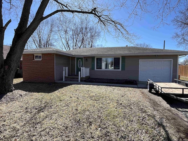 single story home featuring brick siding, driveway, and an attached garage