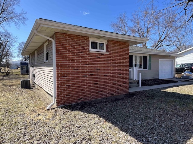 view of side of property with a garage, central air condition unit, and brick siding