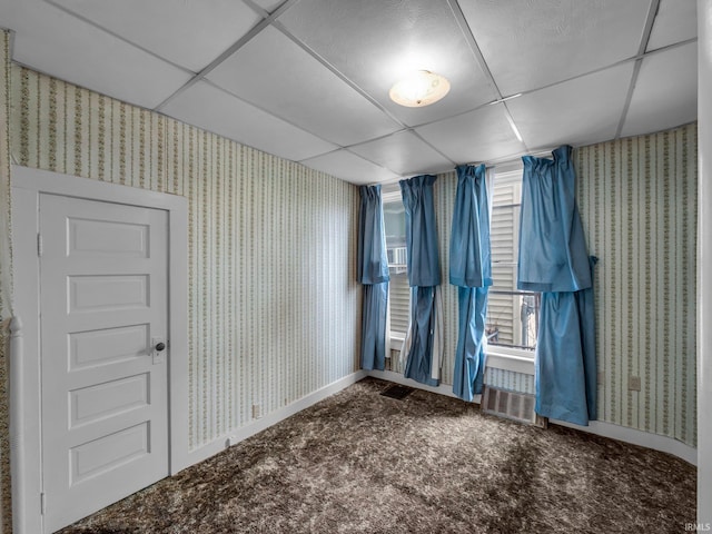 carpeted spare room with a drop ceiling, baseboards, and wallpapered walls