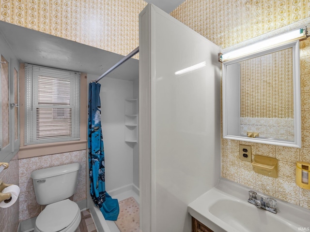 full bathroom featuring wallpapered walls, tile walls, curtained shower, and toilet