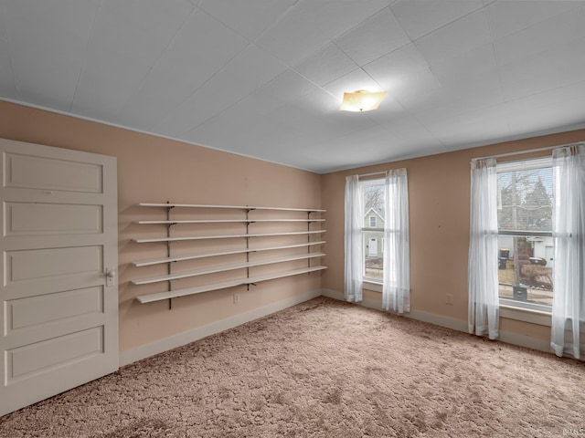 spare room with baseboards and carpet floors