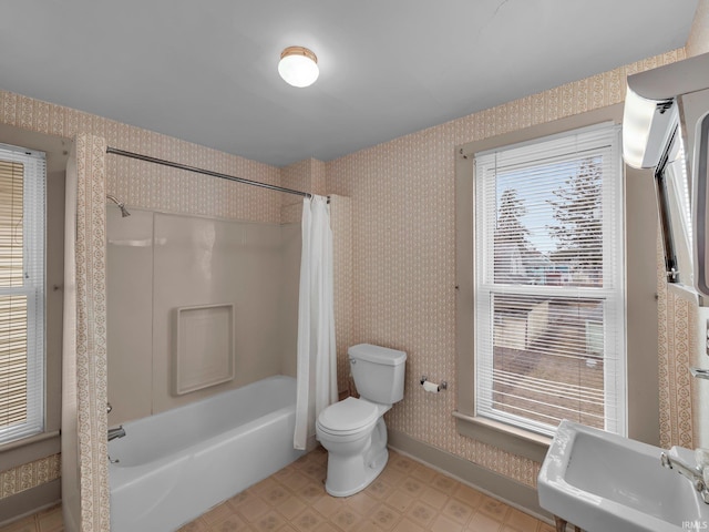 full bathroom with wallpapered walls, toilet, and a sink