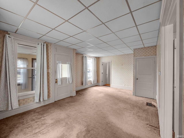 unfurnished room featuring visible vents, wallpapered walls, baseboards, carpet floors, and a paneled ceiling