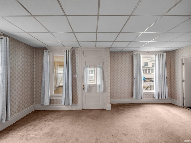 empty room with wallpapered walls, baseboards, and light carpet