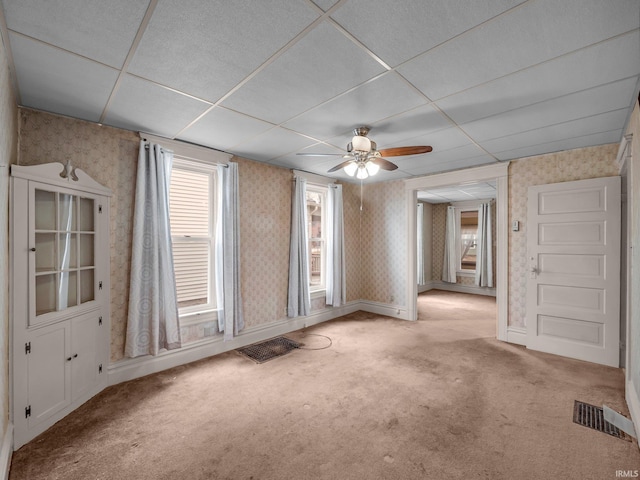 empty room featuring visible vents, wallpapered walls, and carpet floors