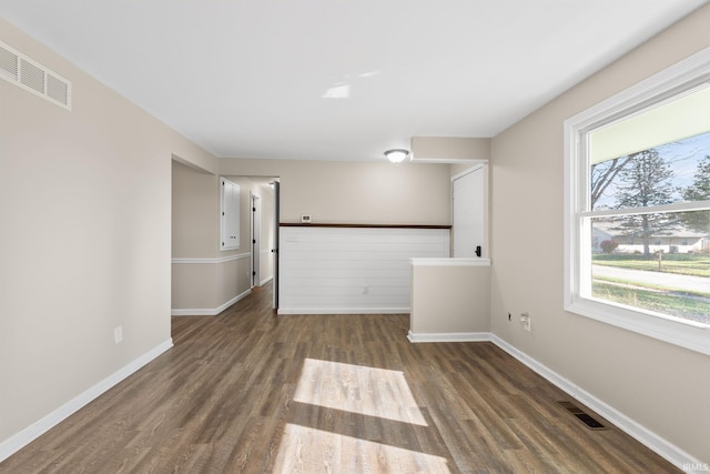 unfurnished room featuring visible vents, baseboards, and wood finished floors