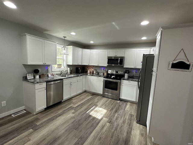 kitchen with visible vents, a sink, dark wood finished floors, appliances with stainless steel finishes, and white cabinets