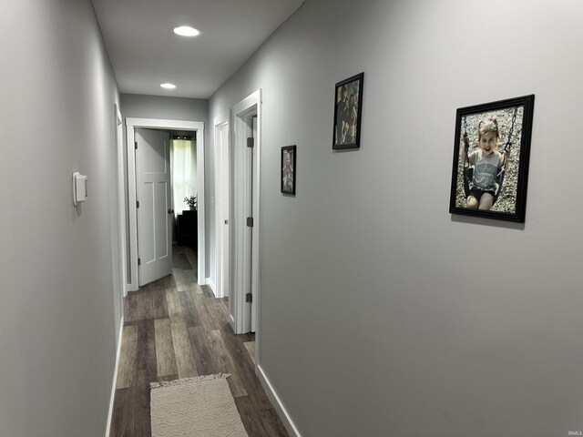 hallway with dark wood finished floors, recessed lighting, and baseboards