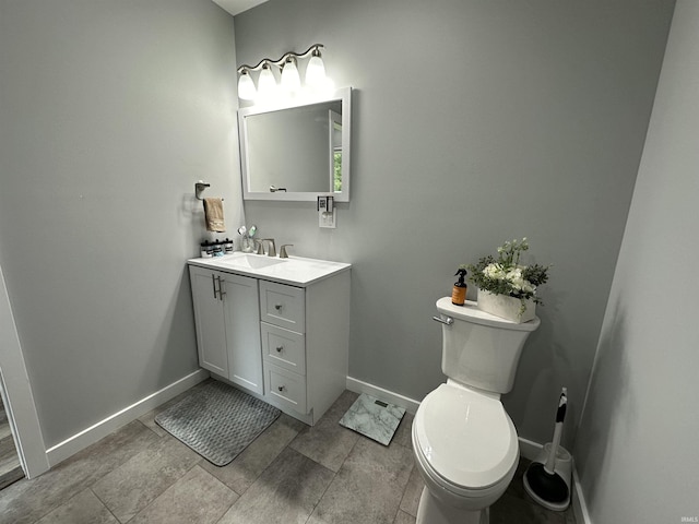 bathroom featuring vanity, toilet, and baseboards