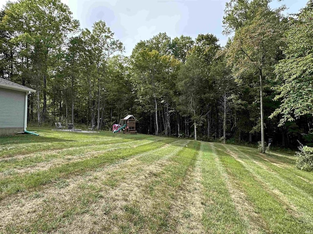 view of yard featuring a wooded view and a playground