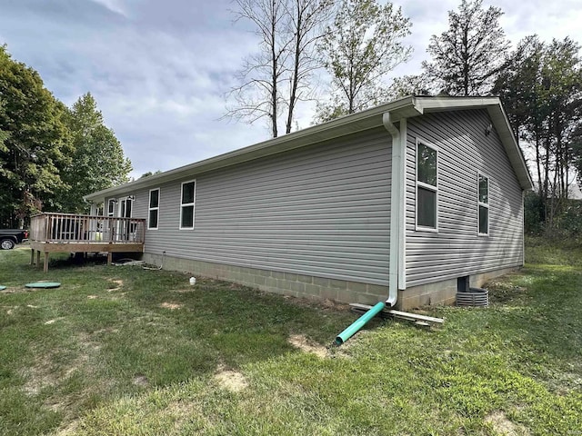 view of side of property with a wooden deck and a lawn