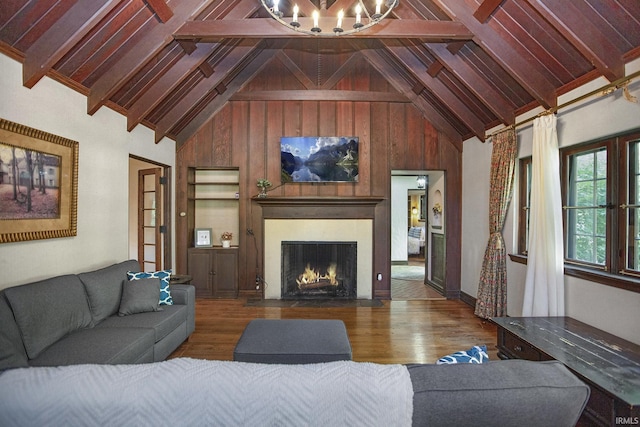 living area featuring a fireplace with flush hearth, high vaulted ceiling, beam ceiling, and wood finished floors