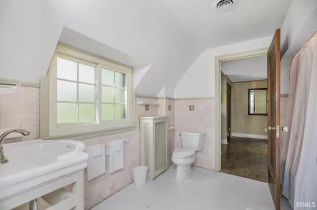 bathroom featuring a sink, visible vents, lofted ceiling, and toilet