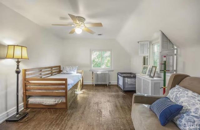 bedroom with a ceiling fan, wood finished floors, radiator, baseboards, and vaulted ceiling