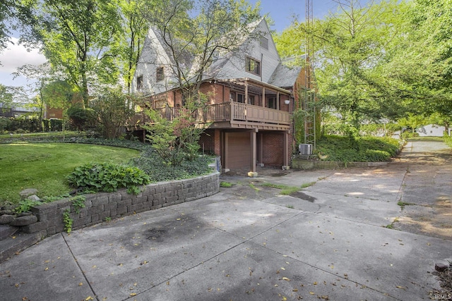 exterior space featuring brick siding, a lawn, an attached garage, and concrete driveway