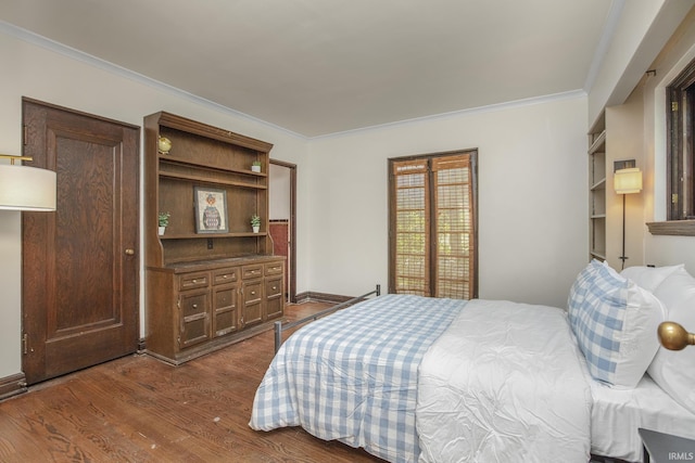 bedroom with baseboards, dark wood-type flooring, and ornamental molding