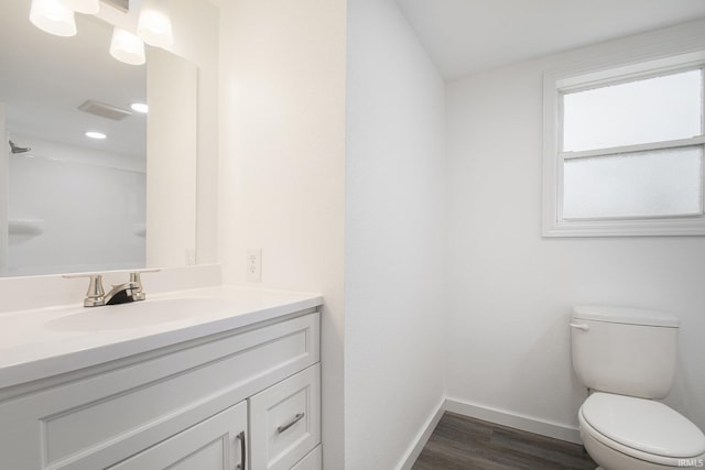 bathroom featuring baseboards, toilet, wood finished floors, and vanity