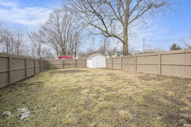 view of yard with an outbuilding, a fenced backyard, and a shed