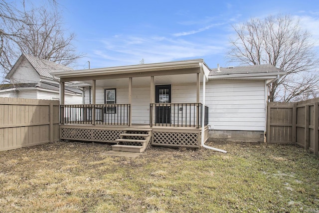 back of property with covered porch and a fenced backyard