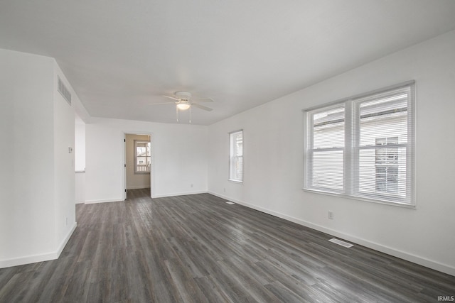 spare room featuring dark wood-type flooring, baseboards, visible vents, and ceiling fan